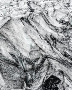 A detailed aerial shot of glacial ice and rock formations showcasing natural textures.