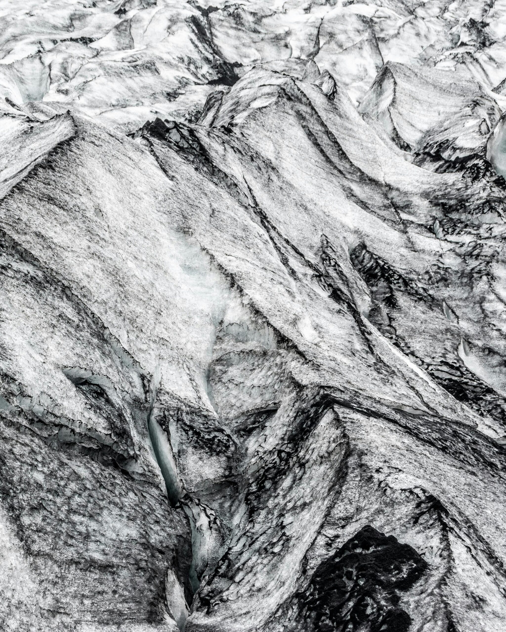 pexels-photo-3220757-3220757 A detailed aerial shot of glacial ice and rock formations showcasing natural textures.